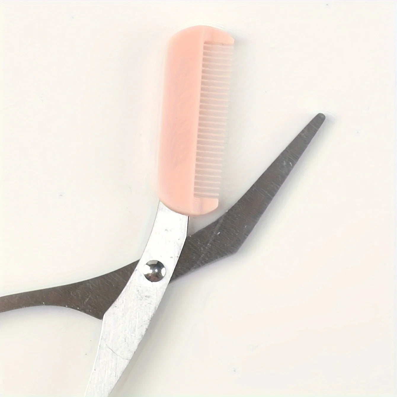 Pink eyebrow trimming scissors with built-in comb - stainless steel, precise grooming tool, creating perfect eyebrows.
