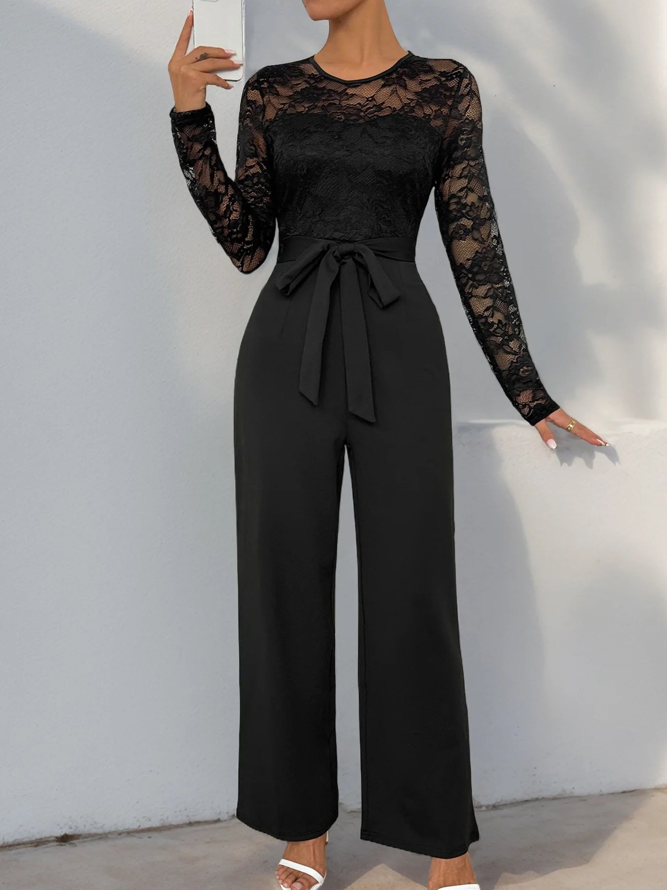 Woman Black Lace Sleeve Jumpsuit Round Neck Belted Waist Ideal for Evening Parties and Cocktail Events.