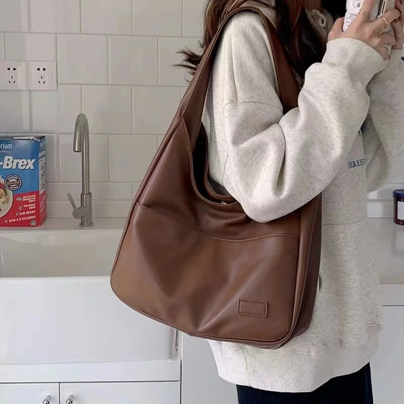 Large capacity tote bag, new black leather simple casual commuting women's bag, fashionable and versatile single shoulder bag.