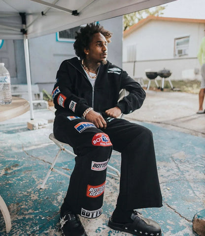 Black trendy patterned hip-hop sportswear set Y2K hooded zipper top with brand logo print and multiple badges streetwear fashion.