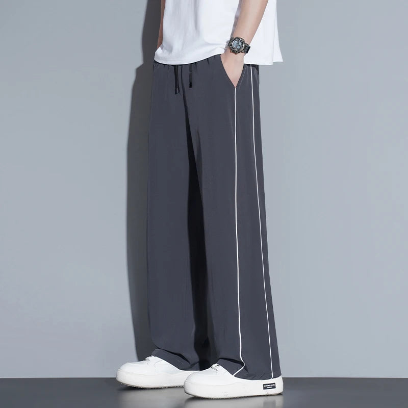 Summer ice silk thin section pants men's Hong Kong style loose splicing casual sports wide-legged pants elastic speed pants.